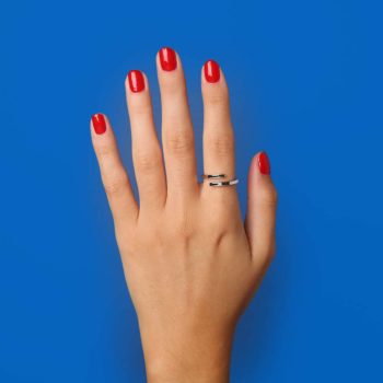 hand on blue background with used Dinh Van ring